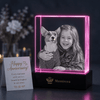 Faceted 15th anniversary photo crystal engraved with a couple's portrait catching light on a shelf